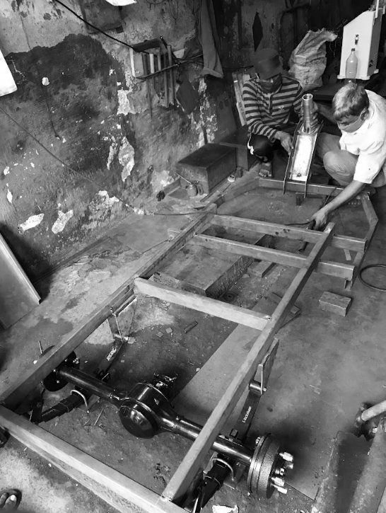 Black-and-white photo of the first chassis being welded at the local fabricator