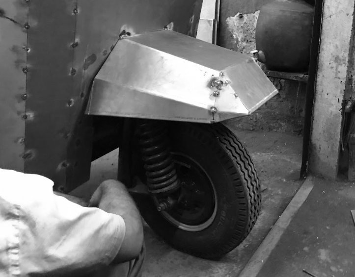 Black-and-white photo of the folded sheet-metal fender over the front wheel