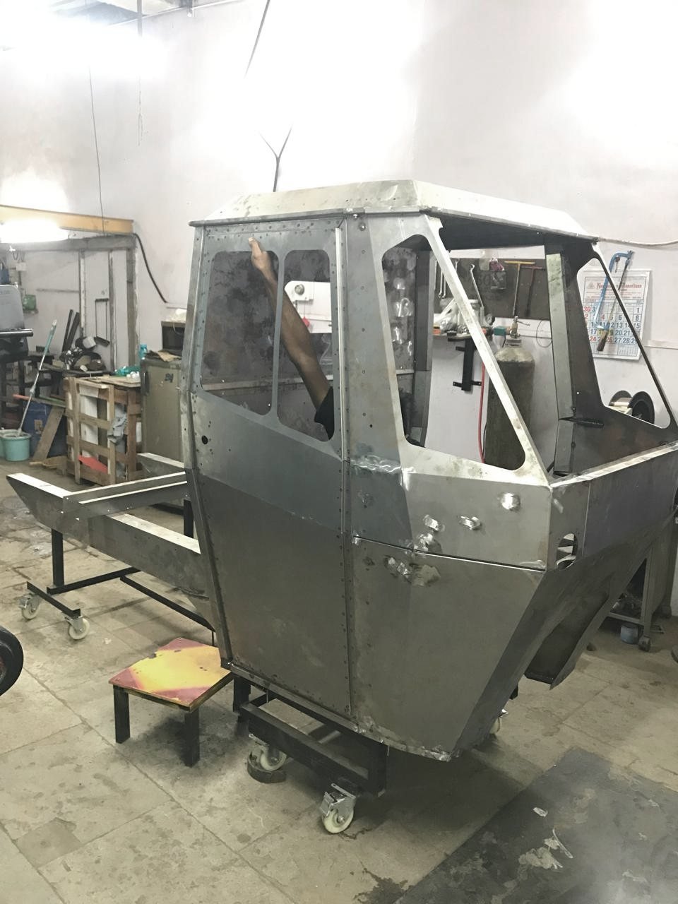 A welded cab rolling on a line trolley through the shop