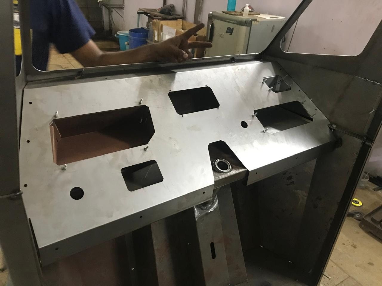 The dashboard mocked up in bare sheet metal inside the cab