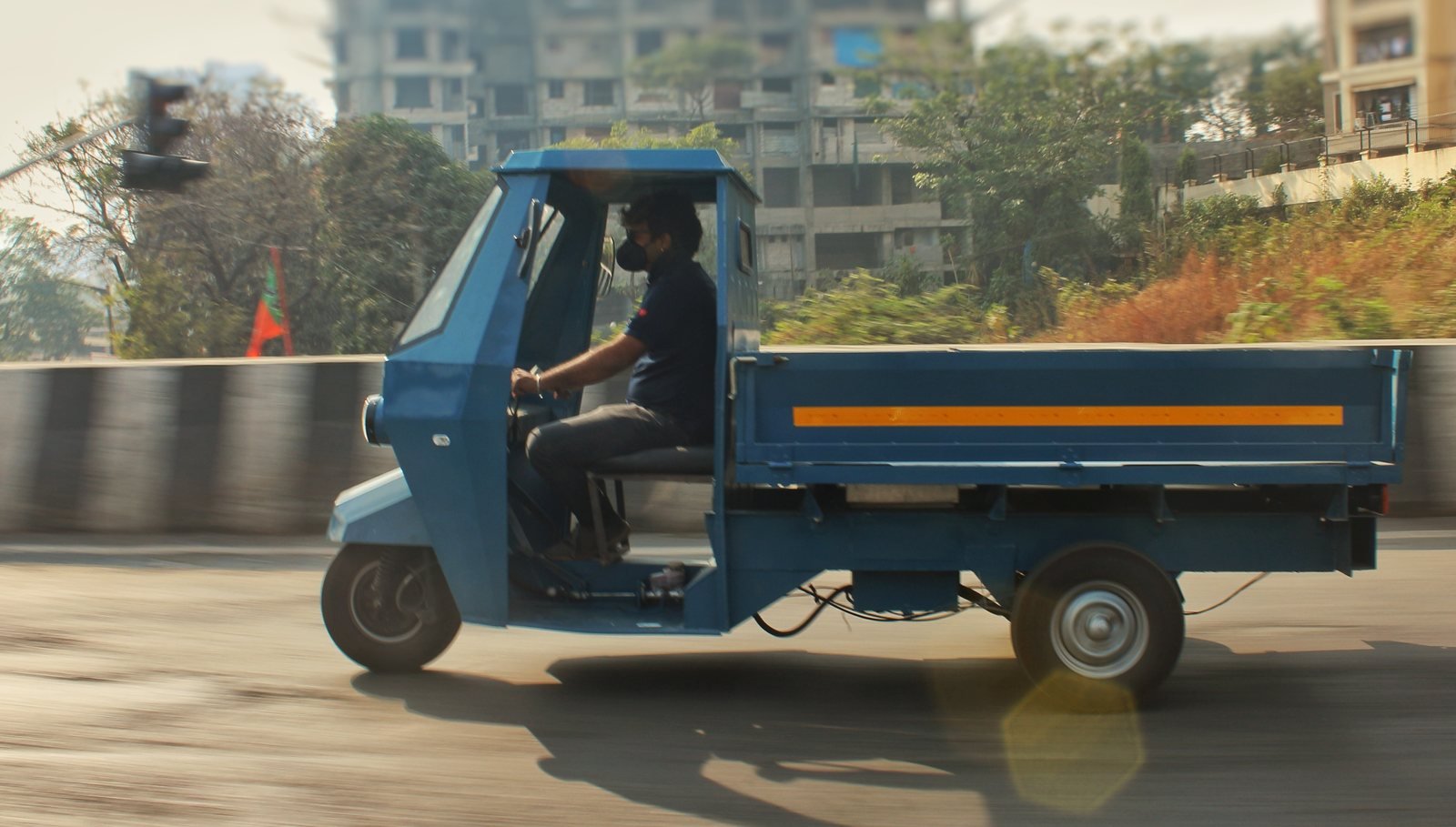 Side view of the blue pilot Navya with an open cargo deck on a road test