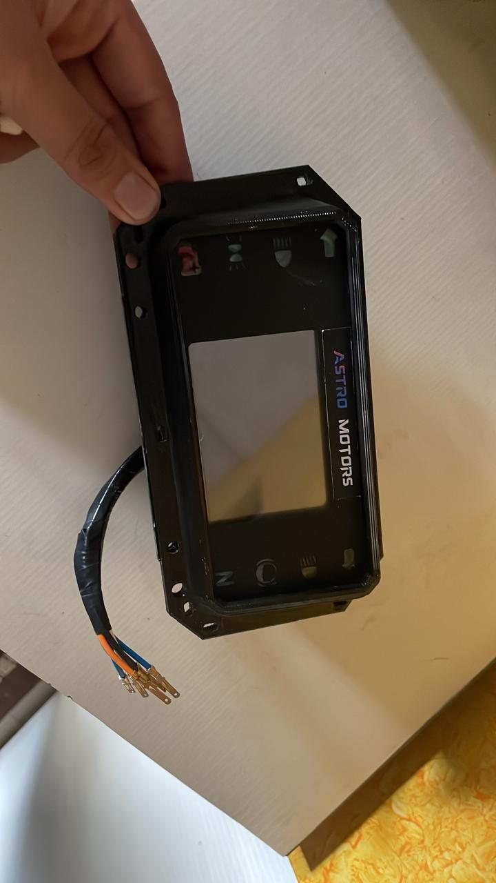 Hand holding the vacuum-cast cluster housing with the Astro Motors display